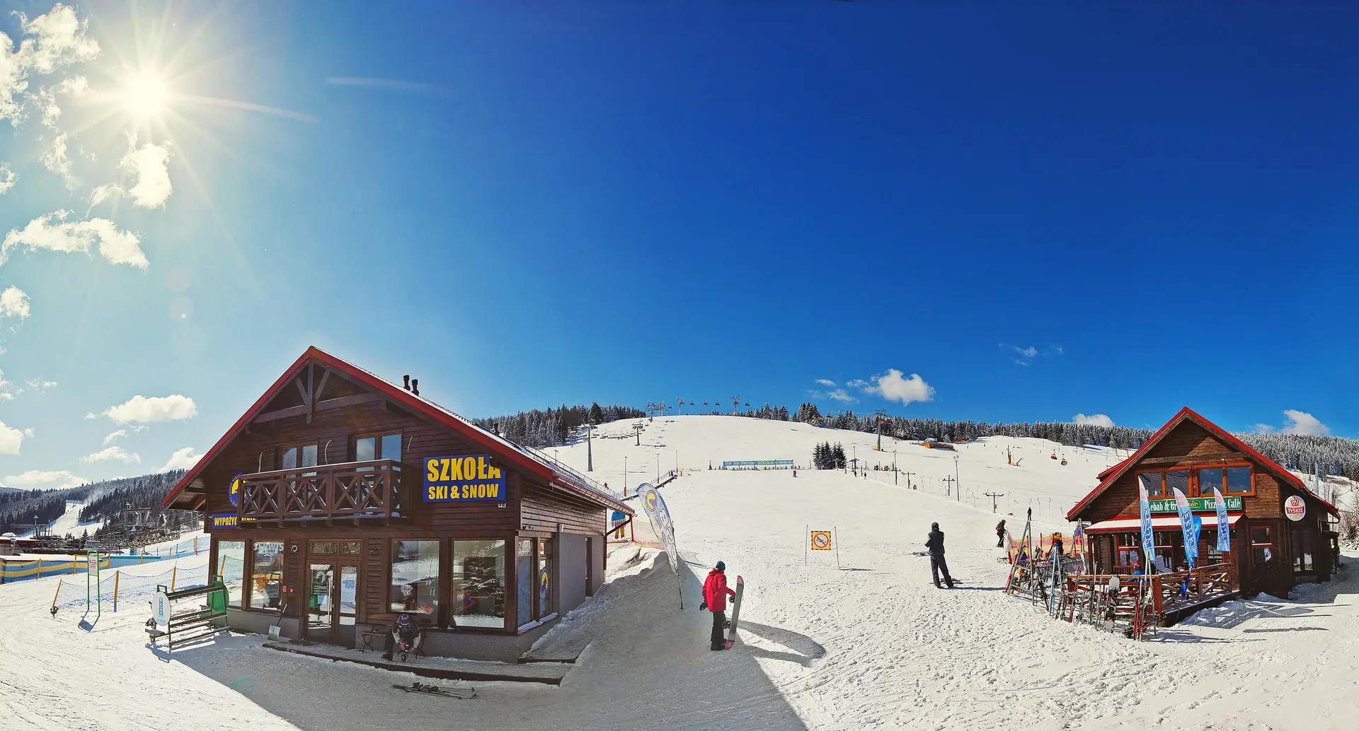 Budynek szkoły Ski & Snow Bartuś w słońcu, na stoku w Zieleńcu